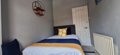 a bedroom with a bed with a yellow and blue at Single Bed at Cozy Hailsham in London