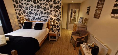 a small bedroom with a bed and a chair at The Strawbury Duck Inn in Darwen