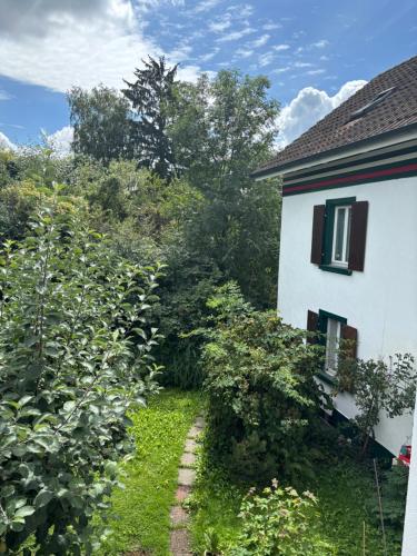 a garden next to a white house with bushes at Kaiseraugst in Kaiseraugst