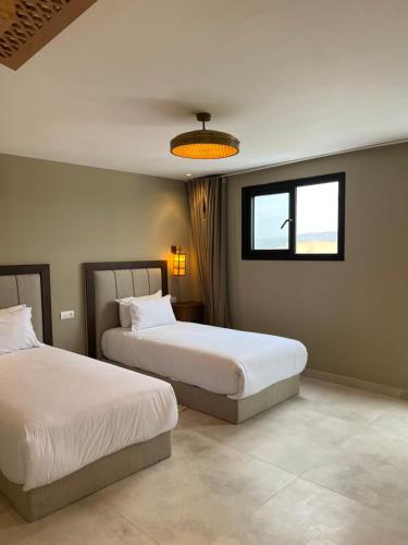 a bedroom with two beds and a window at Cruiser Mogador Essaouira in Essaouira