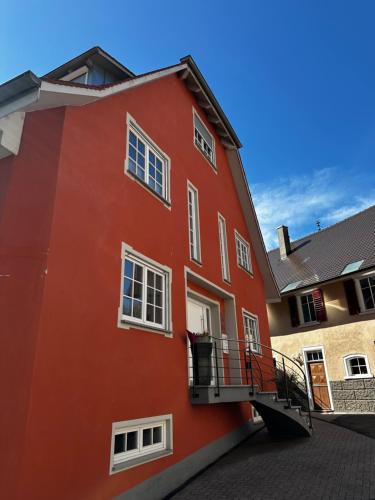 a red building with a balcony on the side at NEU ... in 2 min. am Bodensee in Überlingen