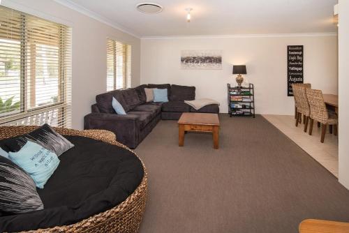 a living room with a couch and a table at Coastal Soul - 10 min walk to beach, town & cafes in Busselton