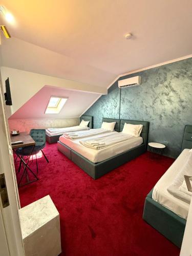 a bedroom with two beds and a red carpet at Pensiunea Margareta in Baile Felix
