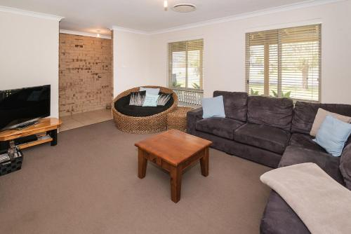 a living room with a couch and a table at Coastal Soul - 10 min walk to beach, town & cafes in Busselton