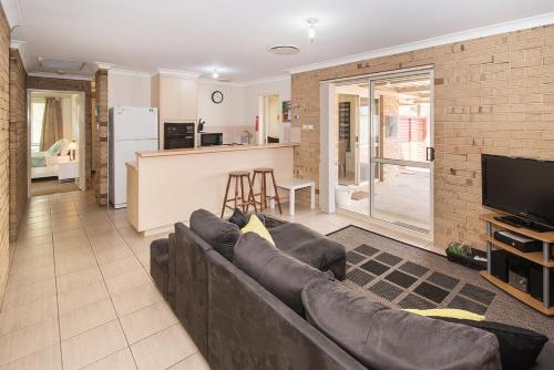 a living room with a couch and a kitchen at Coastal Soul - 10 min walk to beach, town & cafes in Busselton