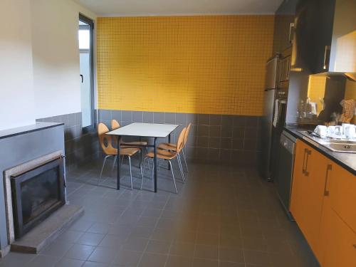 a kitchen with a table and chairs and a fireplace at Candieira in Campia