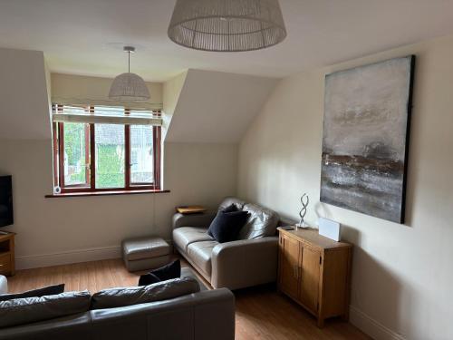 a living room with a couch and a table at Dovera, private parking included, Bowness on Windermere in Bowness-on-Windermere