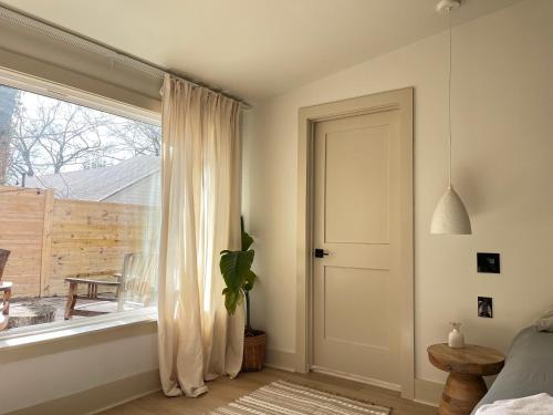 a bedroom with a large window and a door at La Casa de Tutti in Decatur