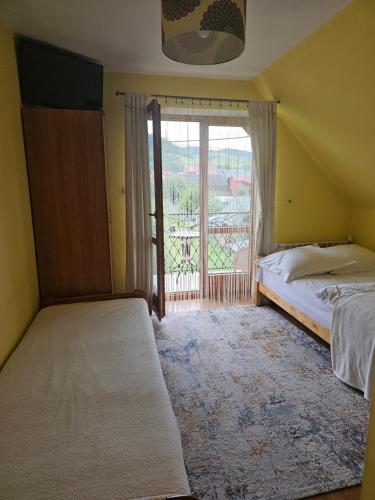 a bedroom with two beds and a large window at Wynajem pokoi Natalia in Sromowce Niżne