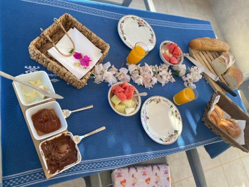 a blue table topped with plates and bowls of food at La Villa Margautin in Arkou