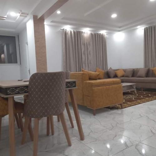 a living room with a couch and a table and chairs at اقامة بيرم Résidence Bayrem in Houmt Souk