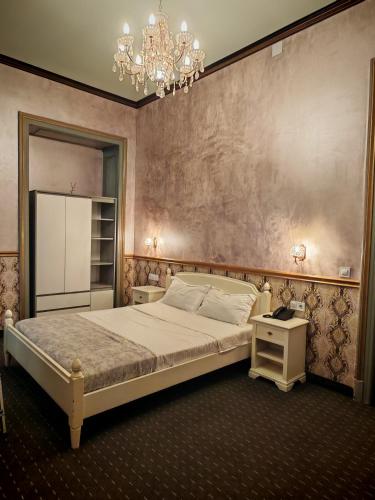 a bedroom with a large bed and a chandelier at Noblesse Palace Old Town by NF in Bucharest