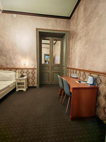 a room with a desk and a bed and a table and chairs at Noblesse Palace Old Town by NF in Bucharest