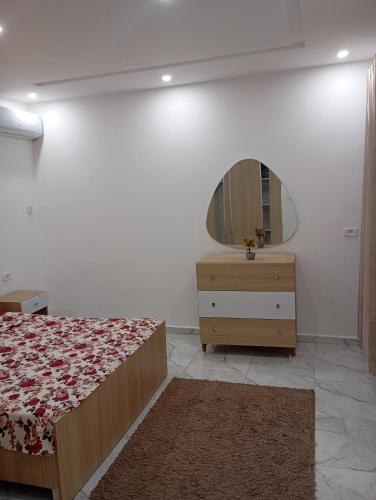 a bedroom with a bed and a dresser and a mirror at اقامة بيرم Résidence Bayrem in Houmt Souk