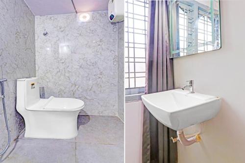 a bathroom with a sink and a toilet and a mirror at Collection O De Alphabet Hotel UMCC in Hyderabad