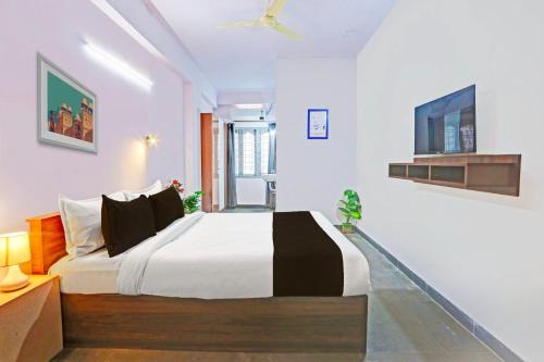 a bedroom with a bed and a ceiling fan at Collection O De Alphabet Hotel UMCC in Hyderabad