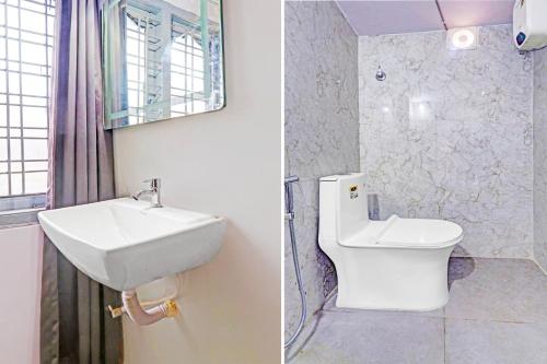 a bathroom with a sink and a toilet and a mirror at Collection O De Alphabet Hotel UMCC in Hyderabad