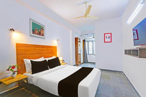 a bedroom with a large bed and a ceiling fan at Collection O De Alphabet Hotel UMCC in Hyderabad
