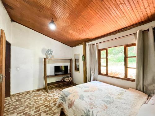 a bedroom with a bed and a wooden ceiling at Chalé Angico - Refúgio Namata in Pirenópolis