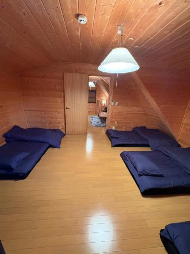 a room with blue pillows on a wooden floor at 裏に川がある貸切別荘 in Takashima