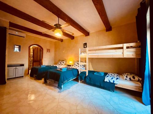 a bedroom with two bunk beds and a ceiling at See You Mystic Flowers & Pool in Għarb