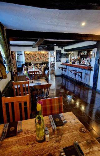 a restaurant with a table and chairs and a bar at The Strawbury Duck Inn in Darwen