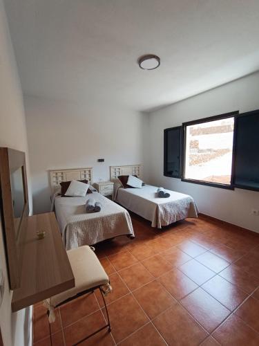 a room with two beds and a window at Casa Rinaifi in Guatiza