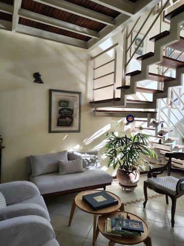 a living room with a couch and a staircase at Casa em Condominio Central in Campinas