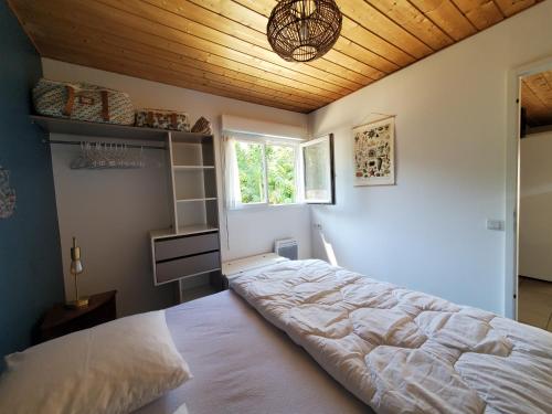 une chambre avec un grand lit avec un plafond en bois dans l'établissement Jolie maison en bois à 600m de la plage des Vergnes, à Meschers-sur-Gironde