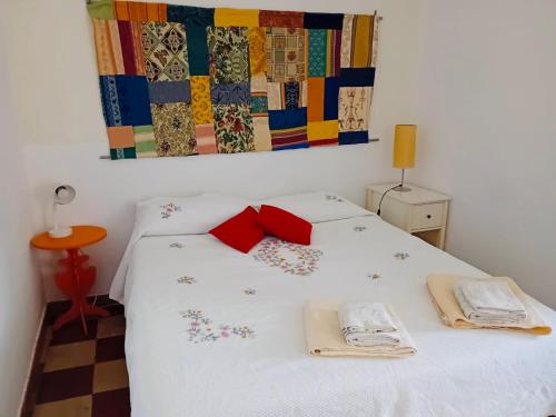 a bedroom with a bed with white sheets and red pillows at Casa Elvira Basilico in Scafa