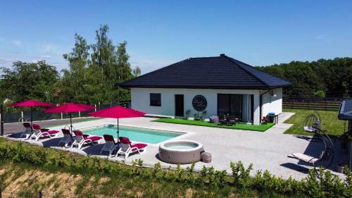 a house with a pool with chairs and umbrellas at La Casa di Anna in Slatina Varoš