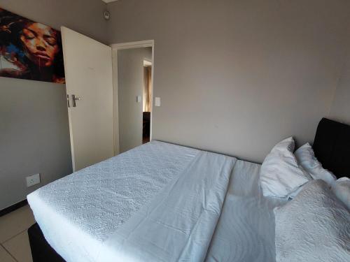 a bedroom with a white bed in a room at Mont Pelaan 88 in Newcastle