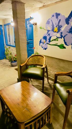 a room with a table and two chairs and a painting at SHIVAYA since 1953 in Mukteswar