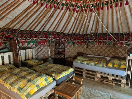 a room with two beds and a table in a yurt at Weddeloase in Medebach