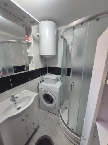 a bathroom with a sink and a washing machine at Apartment Lela - self check-in and check-out in Otočac