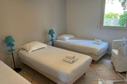 two twin beds in a room with a window at Appartement Lakeside in Hossegor
