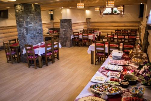 een restaurant met tafels en stoelen met eten erop bij Willa Bukowina in Bukowina Tatrzańska