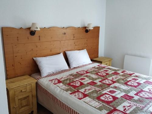 une chambre avec un lit avec une couette dessus dans l'établissement Location saisonnière 3 pièces à Puy-Saint-Vincent, 6 personnes, proche pistes, piscine, parking inclus - FR-1-504-599, à Puy-Saint-Vincent