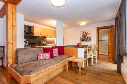 a living room with a couch and a kitchen at Gästehaus Dreier in Neukirchen am Großvenediger