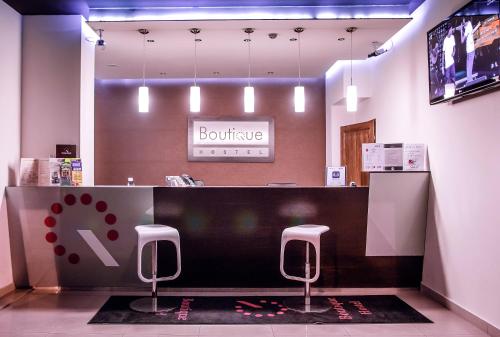 a checkout counter in a store with two stools at Boutique Hostel in Łódź