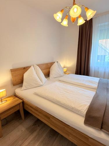 a bedroom with a large white bed with a chandelier at Gina's Landhaus in Eberau