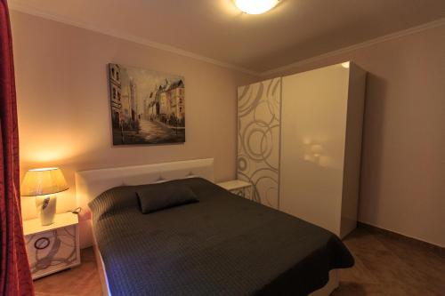 a small bedroom with a bed and a door at Yu&li Rose Apartments Adriatic in Bar