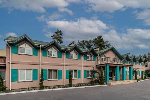 a large building with green and pink trim at Seasons SPA Boutique Hotel in Kozin