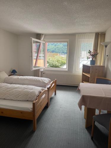 a bedroom with two beds and a window at Hotel ilufa in Meiringen