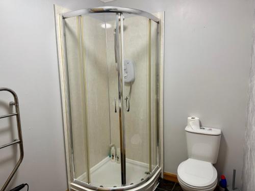 a shower stall with a toilet in a bathroom at The Old Salt House, Flat 2 in Wick