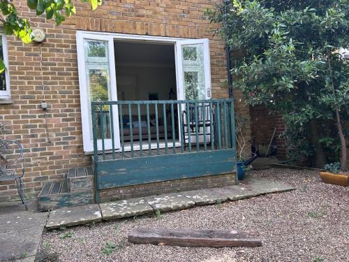 a porch of a brick house with a blue door at Cosy whole home in central Faversham in Kent