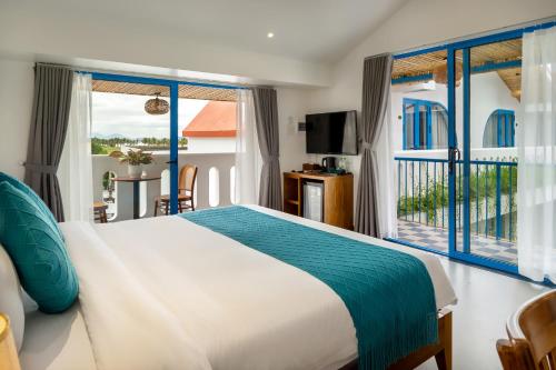 a bedroom with a bed and a balcony at The Linh Coastline Villa in Hoi An