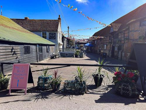 a street with potted plants and a sign in a town at Cosy whole home in central Faversham in Kent