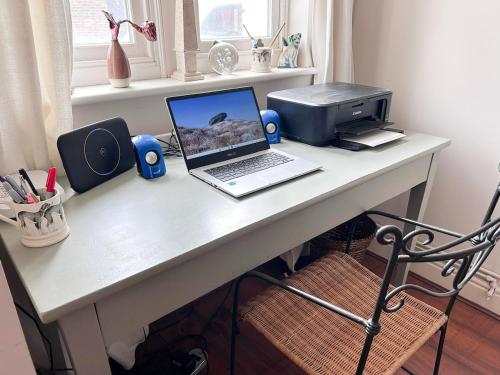 a desk with a laptop computer and a printer at Cosy whole home in central Faversham in Kent