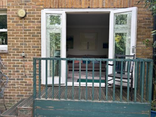 a porch with two chairs on a brick house at Cosy whole home in central Faversham in Kent